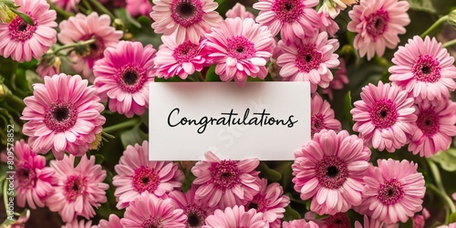 A close-up of pink gerbera daisies with a card saying congratulations  perfect for celebrating special moments