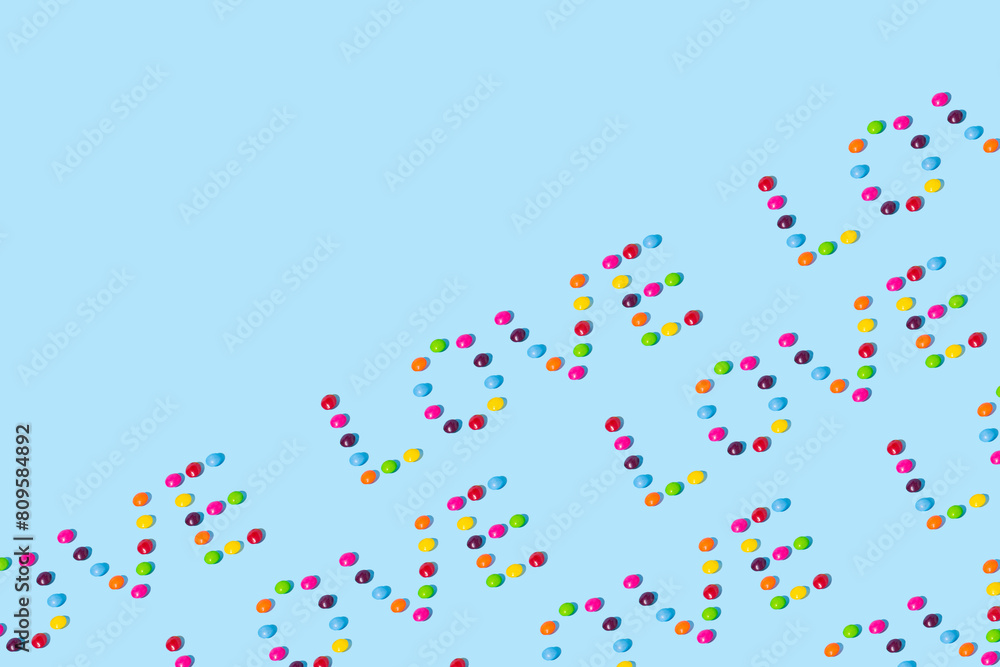 Multi colorued candies arranged on a bright blue background. Abstract pattern. Summer colors background. Minimal love idea concept.