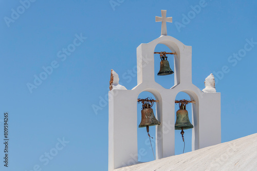 Santorini, Greece, May 3, 2024. Three bells of an Orthodox church with a blue sky