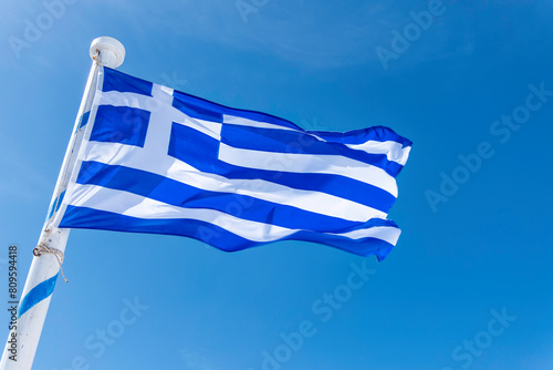 Santorini, Greece, May 3, 2024. Greek flag on the path between Fira and Oia photo