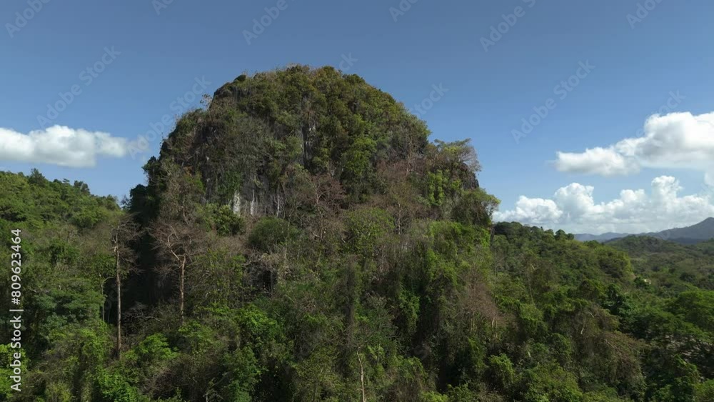 Long and low aerial circling shot around Ille Cave in El Nido, circling around to the striking karst limestone cliff face from a low angle. Long and low aerial circling shot around Ille Cave in El Nido, circling around to the striking karst limestone cliff face from a low angle.