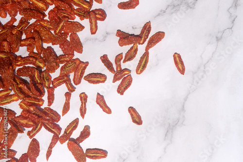 dried cherry tomatoes on white marble background.