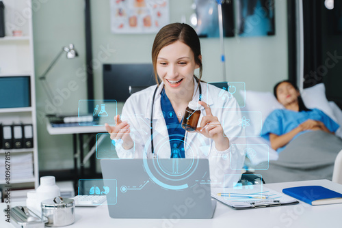 Young female doctor in white medical uniform using laptop and tablet talking video conference call at desk Doctor sitting at desk