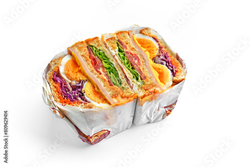 Sandwich with ham, egg, tomatoes, lettuce, and toasted bread. Above view isolated on white background.