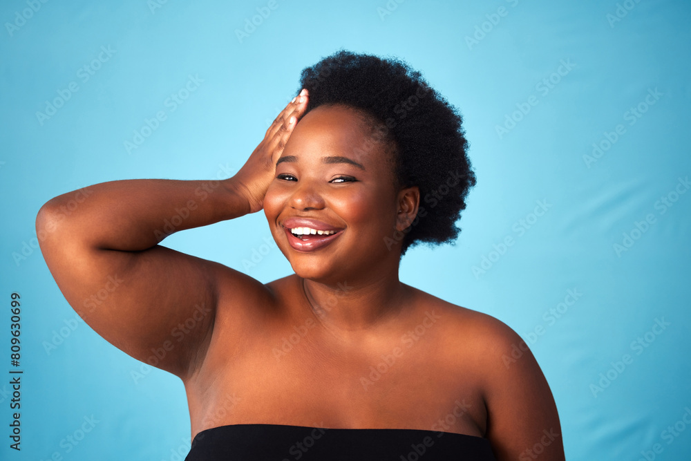 Black woman, blue background and hair care with glow or hands for wellness, soft afro for aesthetics. Female person, studio and portrait with hairstyle for cosmetic, plus size with confidence