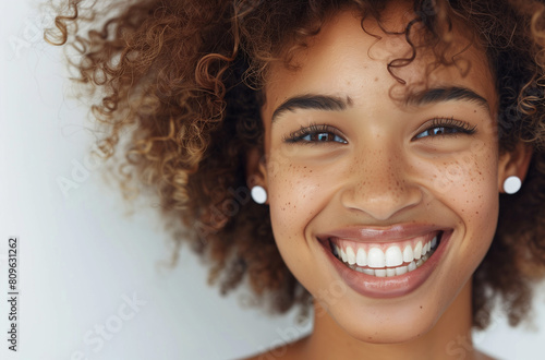 Happy young woman with curly afro hair and a bright  cheerful smile.