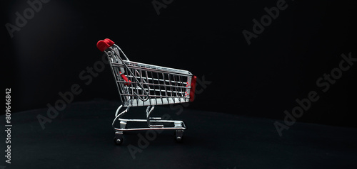 Mini shopping cart on dark background photo