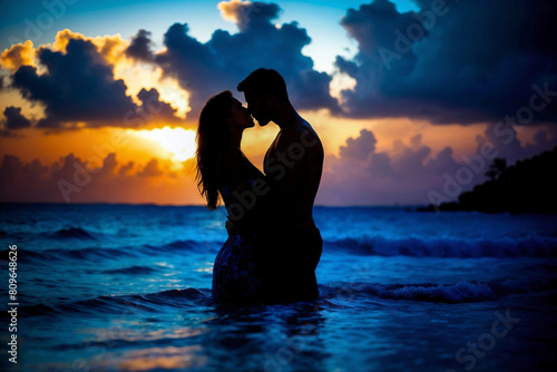 Fototapeta Naklejka Na Ścianę i Meble -  Silhouette of a romantic couple out in the sea kissing as the sun sets over the horizon. Two lovers on a beach sharing an intimate kiss under a beautiful sunset on their honeymoon in the Caribbean.
