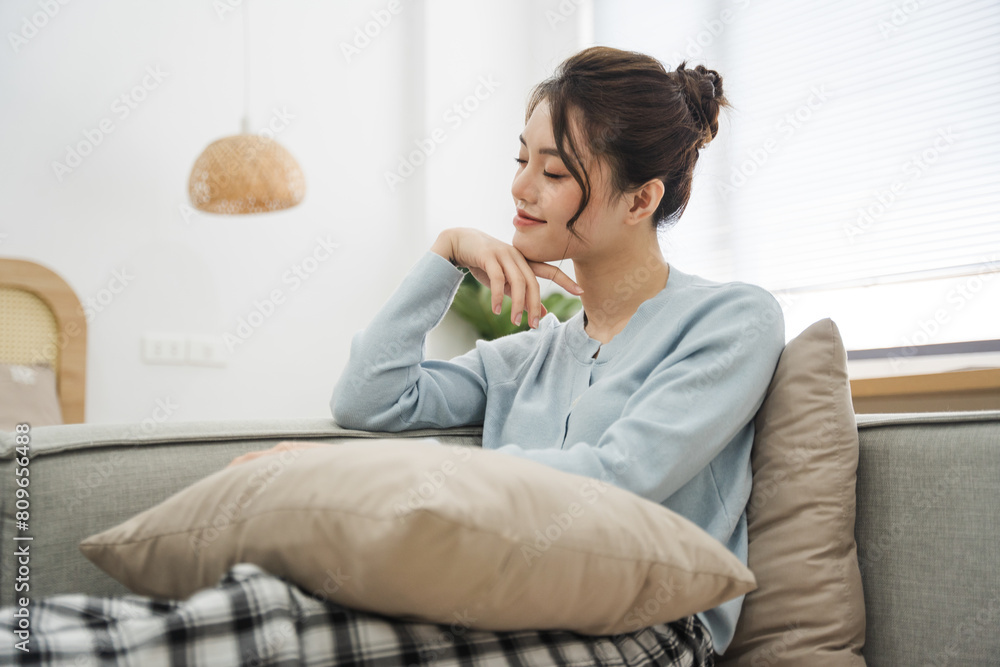 Portrait of Asian woman sitting on sofa at home Portrait of Asian woman sitting on sofa at home