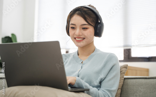 Portrait of Asian woman sitting on sofa at home © 1112000