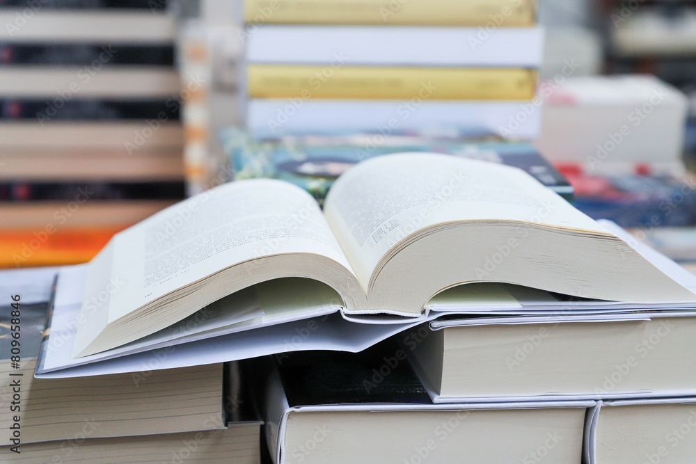 Open book on table with blur bookshelf background Open book on table with blur bookshelf background