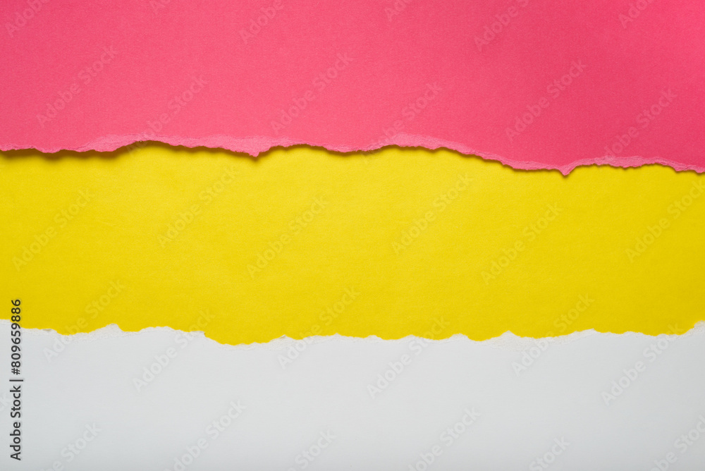 Obraz premium Torn pieces of red and white paper on yellow background. Torn edges.