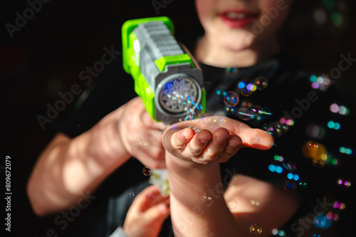 Shooting Bubbles from Bubble Blower. soap bubbles on children's palms photo