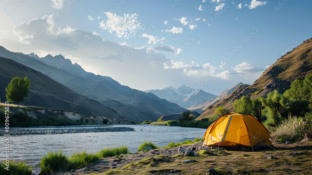 Tent at the foot of the mountain and on the shore of the lake, travel concept