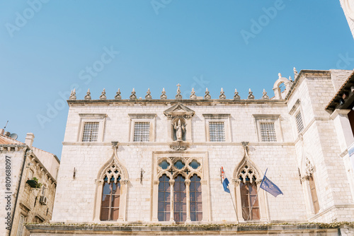 Lancet windows and sculpture on the facade of the ancient Sponza Palace. Dubrovnik, Croatia photo