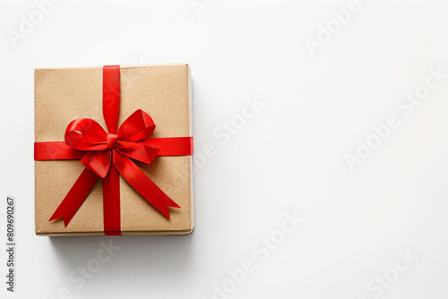 Kraft paper box with a red ribbon bow. The concept of a gift for a birthday, Christmas, Valentine's day. A place for the text.