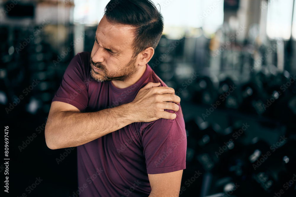 An active man made a shoulder injury at the gym during a workout, feeling a lot of pain. An active man made a shoulder injury at the gym during a workout, feeling a lot of pain.