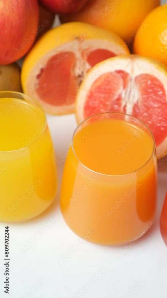 Different fruit juices in glasses on white background, vertical shoot Different fruit juices in glasses on white background, vertical shoot