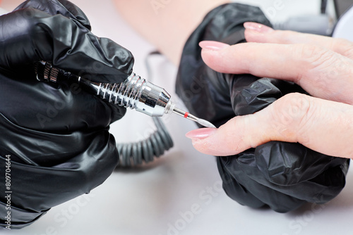 A girl doing a manicure using a nail drill