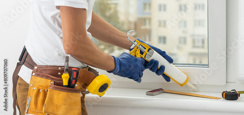 Εκτύπωση καμβά Construction worker sealing window with caulk indoors