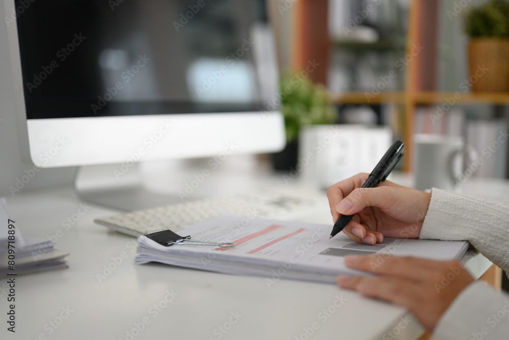 Accountant making financial report, writing some papers at office desk Accountant making financial report, writing some papers at office desk