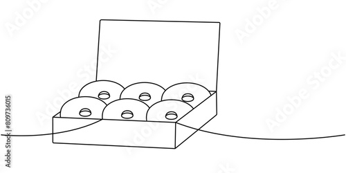 Donuts in a cardboard box one line continuous drawing. Bakery sweet pastry food. Vector linear illustration.