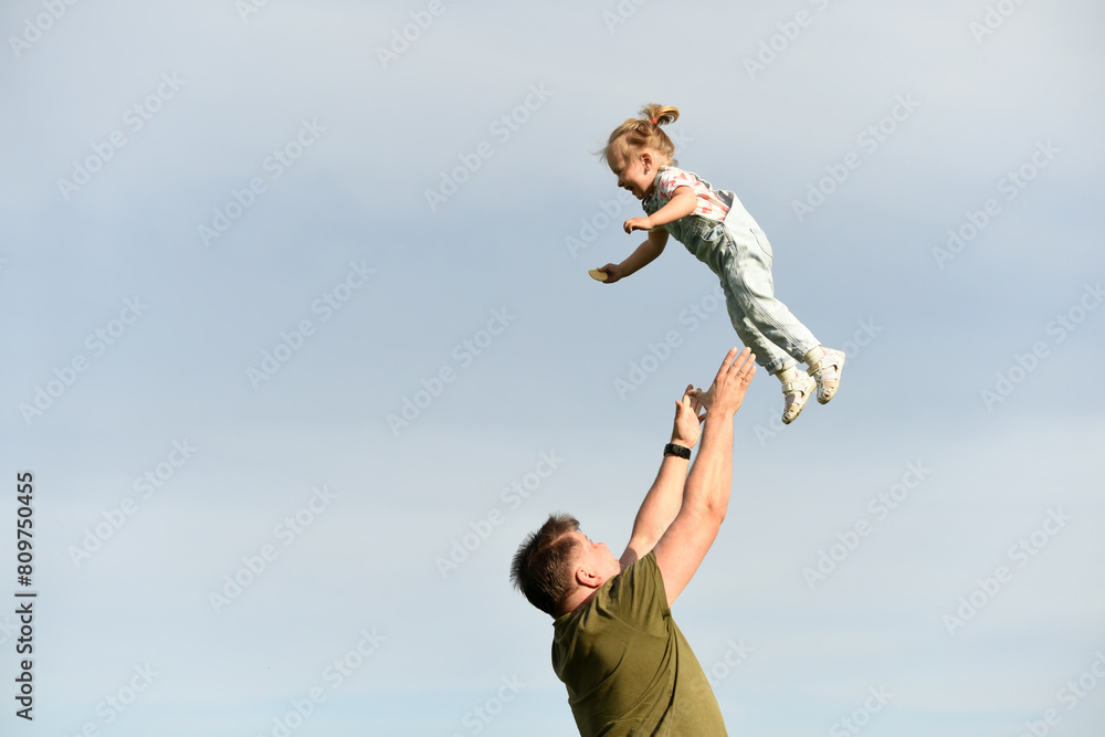 Dad throws up a small child. A parent plays with his daughter. Little girl plays with dad Dad throws up a small child. A parent plays with his daughter. Little girl plays with dad