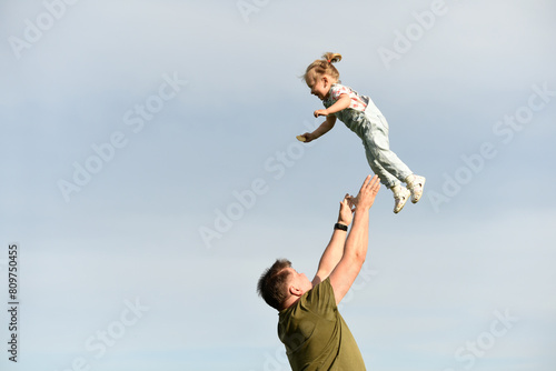 Dad throws up a small child. A parent plays with his daughter. Little girl plays with dad