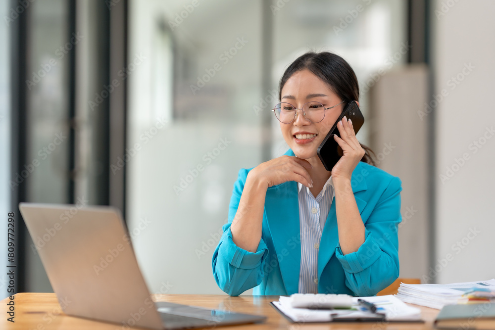 Asian businesswoman modern professional talking with client on the phone with a confident demeanor and effective communication skill. business, marketing, sale and communication project. Asian businesswoman modern professional talking with client on the phone with a confident demeanor and effective communication skill. business, marketing, sale and communication project.