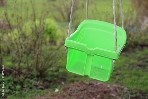 empty green outdoor plastic baby swing