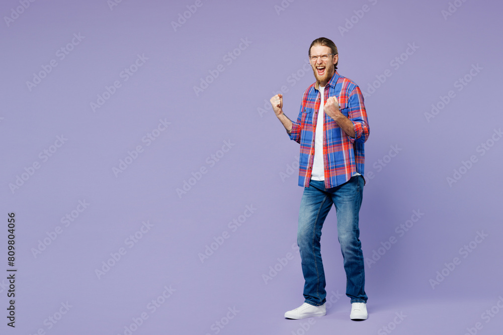 Full body side view young happy man wear blue shirt casual clothes doing winner gesture celebrate clenching fists isolated on plain pastel light purple background studio portrait. Lifestyle concept Full body side view young happy man wear blue shirt casual clothes doing winner gesture celebrate clenching fists isolated on plain pastel light purple background studio portrait. Lifestyle concept
