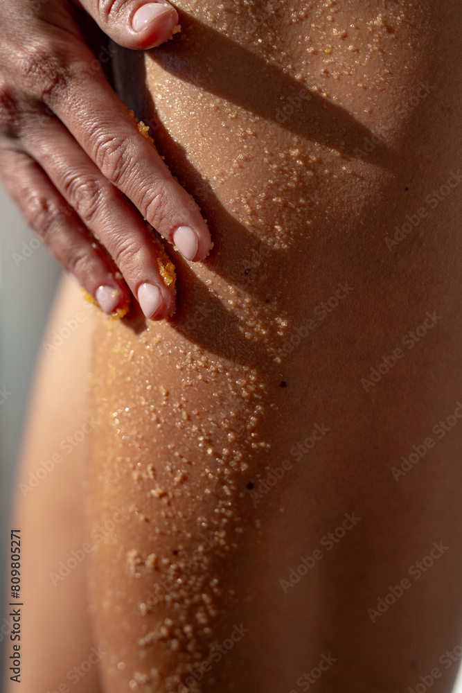 Anti-cellulite wrapping procedure with scrub, close up plan of buttocks and legs Anti-cellulite wrapping procedure with scrub, close up plan of buttocks and legs
