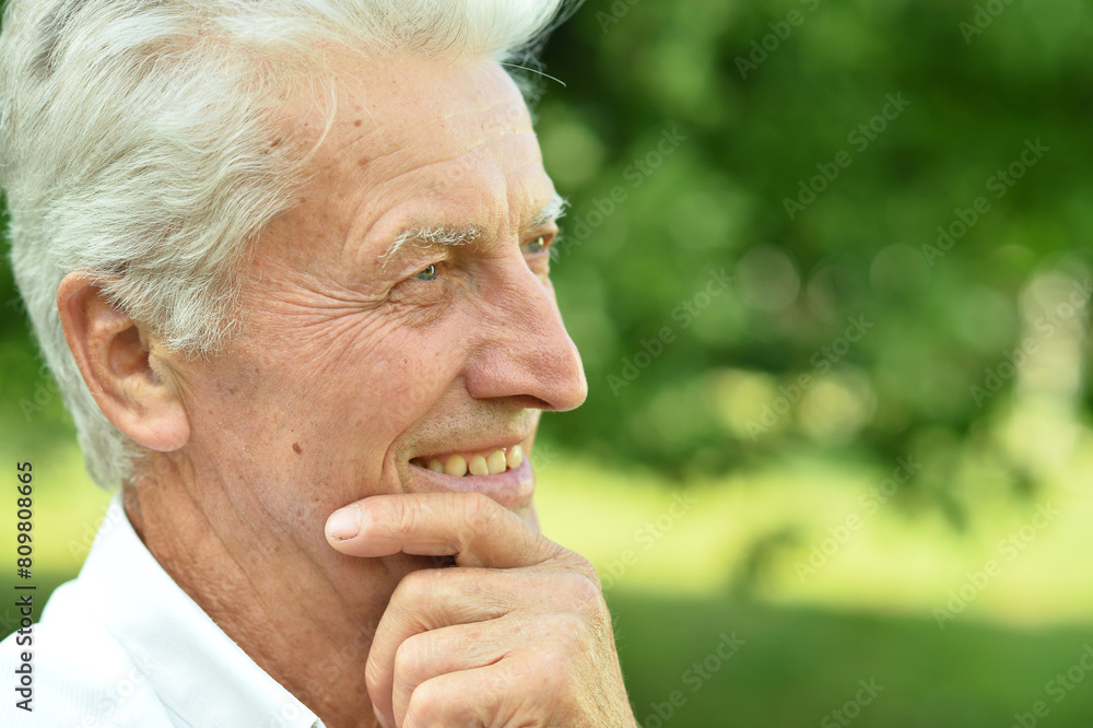 Close up portrait of smiling senior man in park Close up portrait of smiling senior man in park