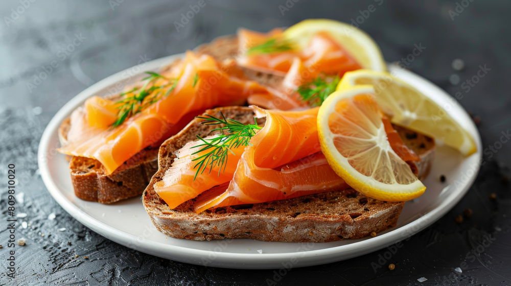 Delicious latvian open sandwich with smoked salmon, fresh dill, and lemon slices on dark rye bread, served on a ceramic plate