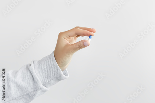 hand holding medical capsule on white background