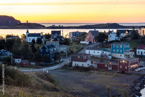 A small town by the edge of the ocean with simple houses and a church  outside lights are still on as dawn beaks  Goose Cove   Trinity  Newfoundland  Canada