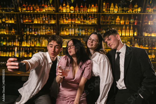 Young people take photo on phone with alcoholic cocktails after noisy party. Group photo of happy friends at holiday in night club