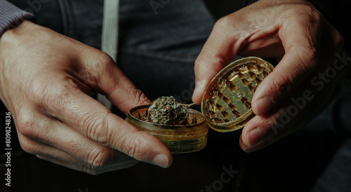 man about to grind a cannabis bud, web banner