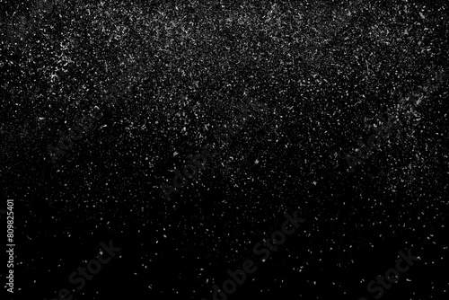 Freeze motion of white powder coming down, isolated on black, dark background. Abstract design of falling dust cloud. Particles cloud screen saver, wallpaper with copy space. Rain, snow fall concept photo