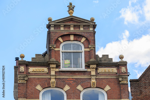 Historic house facades in brick construction with decorations and the year of construction in the city of Delft in the Netherlands photo