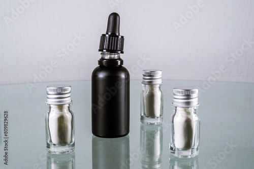 Glass jars with cbd isolate and black bottle with cbd oil photo