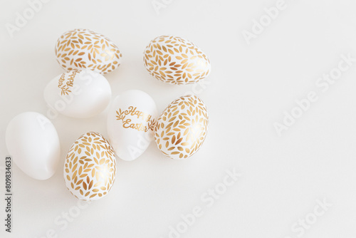 Golden Easter eggs on white background. Easter celebration concept. Flat lay. Top view