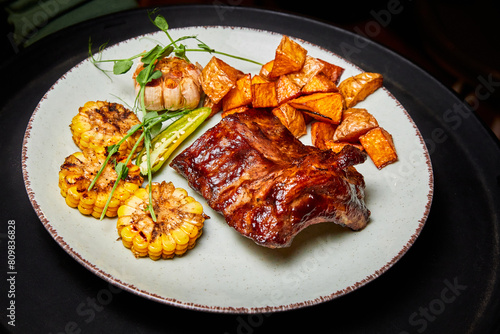 Grilled pork ribs with corn on the cob and baked potatoes