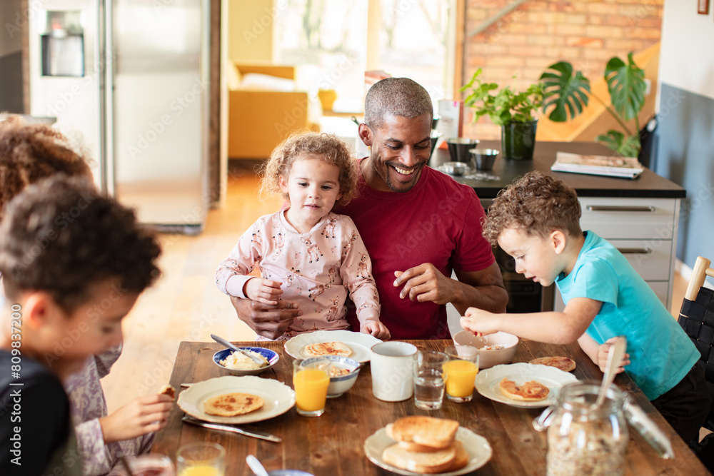 Happy single father having breakfast together with children at home Happy single father having breakfast together with children at home