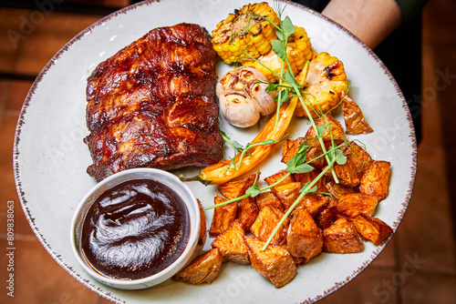 Grilled pork ribs with corn on the cob and baked potatoes