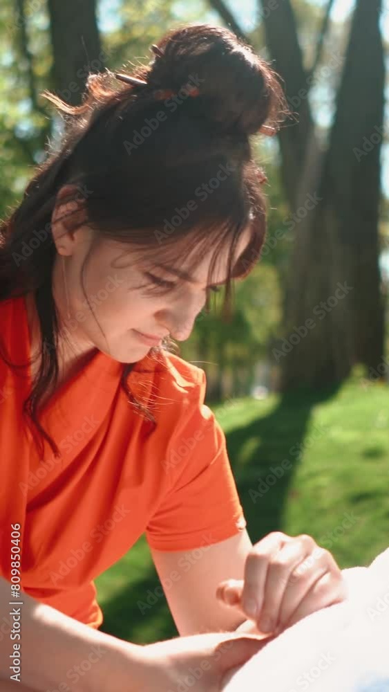 A master masseur in a bright orange uniform gives a healing body massage to a handsome man with muscles. Sports, recreation, health, relaxation and self-care in the summer outdoors A master masseur in a bright orange uniform gives a healing body massage to a handsome man with muscles. Sports, recreation, health, relaxation and self-care in the summer outdoors