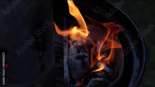 inquadratura in primo piano del fuoco che brucia le carbonelle, all'interno di una griglia photo