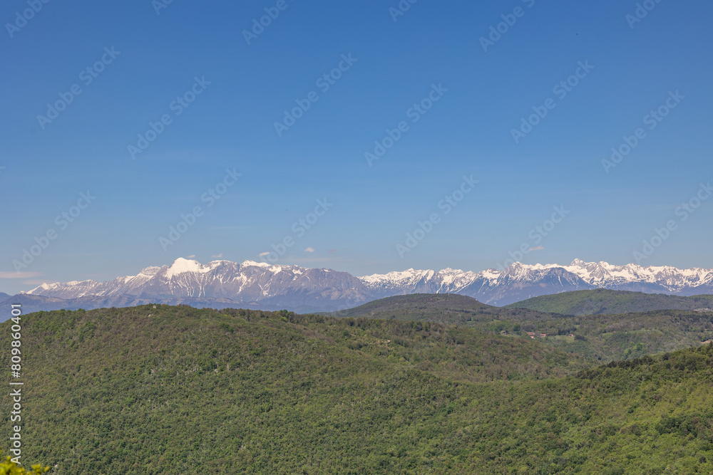 vista dettagliata e dall'alto delle varie catene di colline e montagne tra la Slovenia e l'Italia, viste da lontano, durante una giornata estiva con un cielo sereno