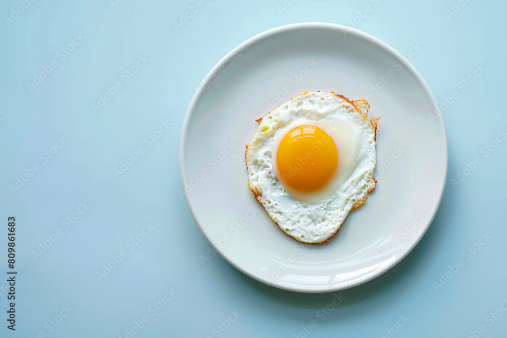 a fried egg on a plate on a blue surface a fried egg on a plate on a blue surface
