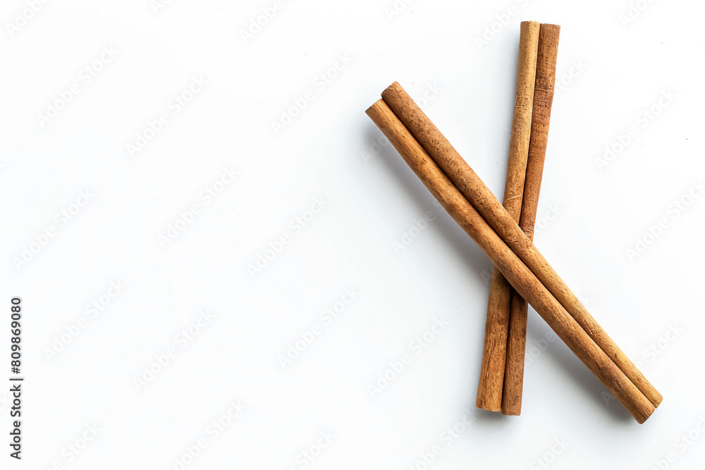 two cinnamon sticks on a white surface two cinnamon sticks on a white surface